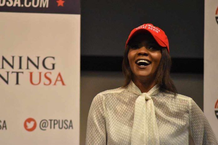 A woman wearing a red cap and a white blouse speaking at a political event