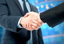 Venezuela’s Shocking Alliance: Russia, China, Iran Two business professionals shaking hands in a corporate setting