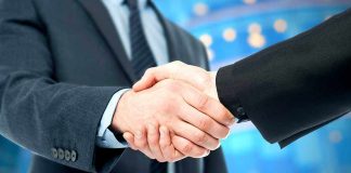 Two business professionals shaking hands in a corporate setting