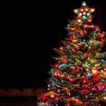 A beautifully decorated Christmas tree with colorful lights against a dark background