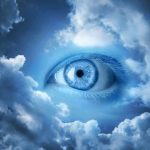A large blue eye emerging from a cloudy sky