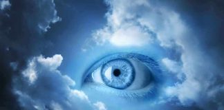 A large blue eye emerging from a cloudy sky