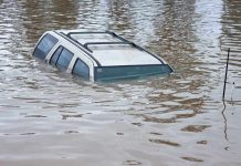 100,000 EVACUATED – Severe Flooding Wrecks State A partially submerged vehicle in floodwaters