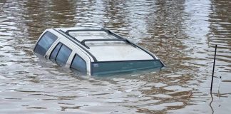 A partially submerged vehicle in floodwaters