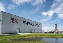 SpaceX building with American flag and launch pad.