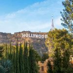 Hollywood’s BOMBSHELL Harassment Lawsuit Explodes Hollywood sign on hill surrounded by trees and buildings.