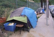 LA’s Homeless Funds Fuel Luxury Jets Tents and belongings set up along sidewalk.