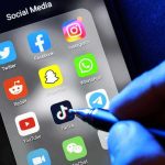 Deputy Arrested After SHOCKING Snapchat Scandal Social media apps on phone screen with hand holding stylus.