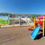 Colorful playground slide in front of a building.