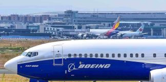 Boeing 737-800 on airport runway with other planes.