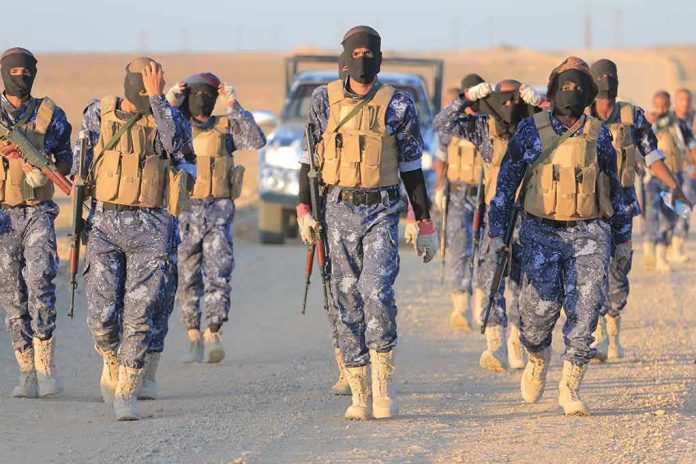 Camouflaged soldiers wearing masks and vests walk in desert.