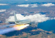 Passenger airplane with rocket engine flying over countryside