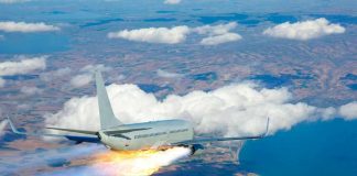 Passenger airplane with rocket engine flying over countryside