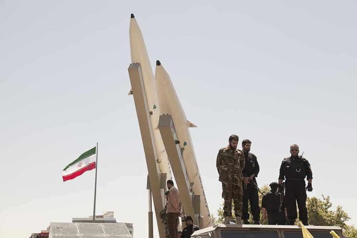 681421708 Military personnel beside missiles and Iranian flag.