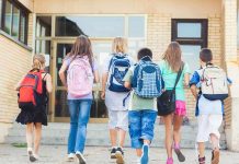 Mother’s Discovery THREATENS Schools Nationwide Group of children walking towards a school entrance with backpacks