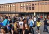 A large group of students socializing outside a school building
