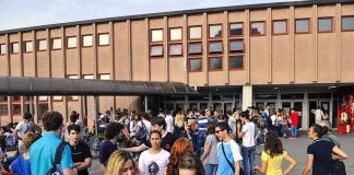A large group of students socializing outside a school building