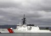 A U.S. Coast Guard ship docked under cloudy skies