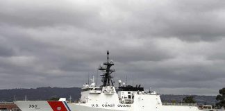 A U.S. Coast Guard ship docked under cloudy skies