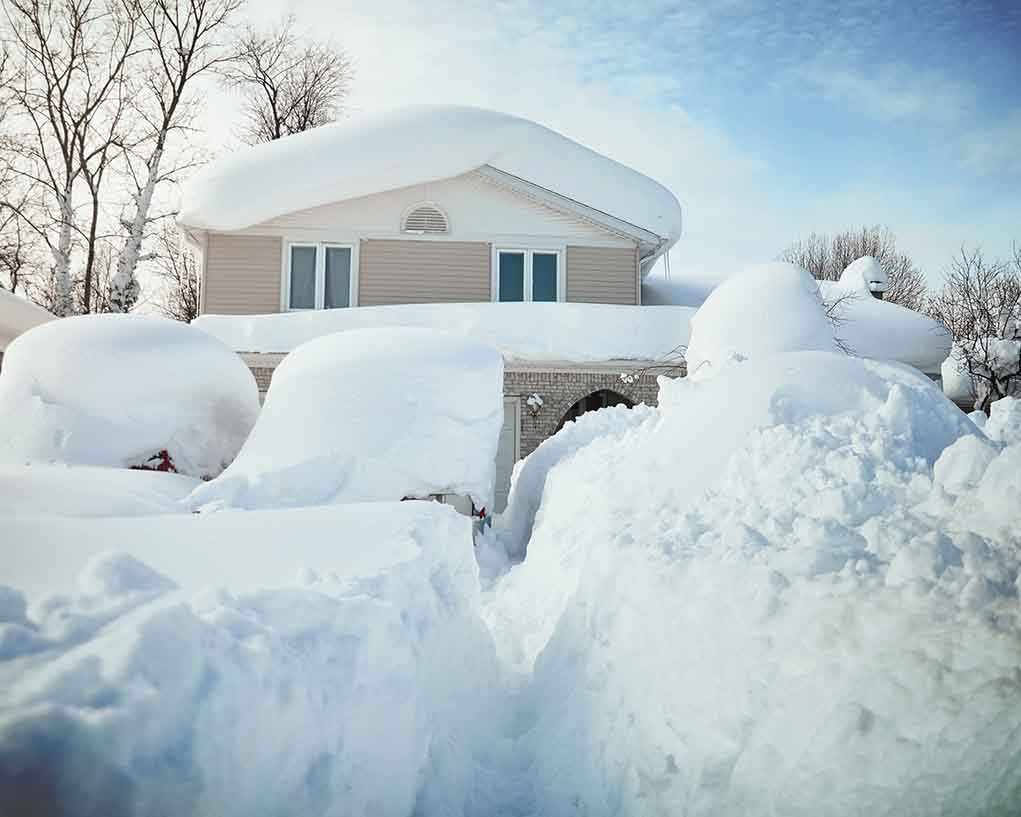 A house surrounded by deep snow drifts after a heavy snowfall