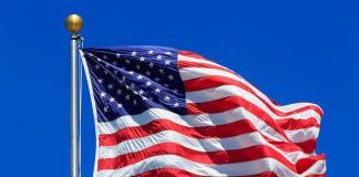 Waving American flag against a clear blue sky