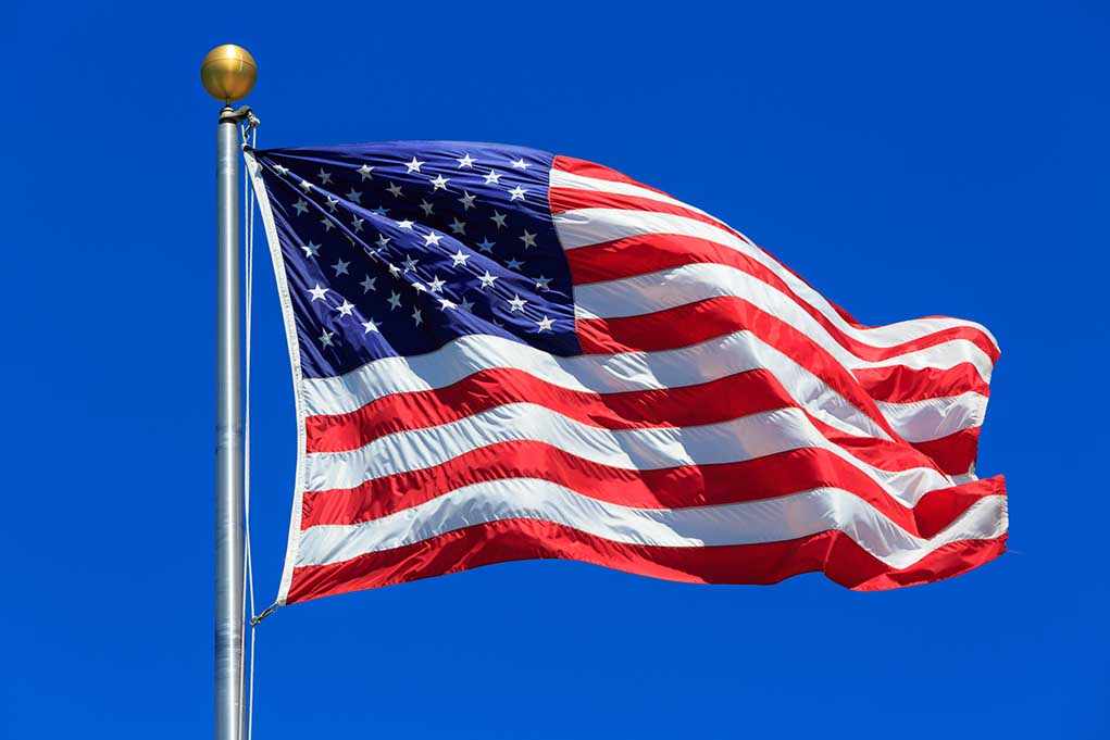 Waving American flag against a clear blue sky