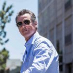 Newsom’s MASSIVE Water Spend—While Infrastructure Crumbles Man in sunglasses wearing a blue button-up shirt.