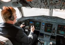 Airlines Under Fire: DEI Practices BANNED Pilot in cockpit operating airplane controls.