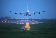 Rosie’s Secret U.S. Visit After Ireland Move An airplane approaching the runway at night with landing lights illuminated