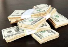 Stacks of bundled cash on a wooden table