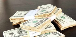 Stacks of bundled cash on a wooden table