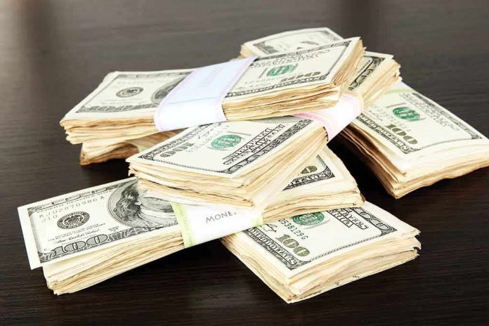 shutterstock_146671502.jpg Stacks of bundled cash on a wooden table