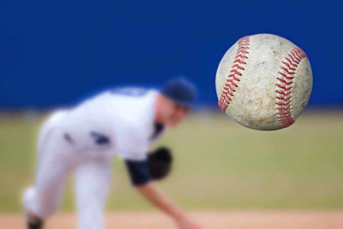 shutterstock_147286310.jpg A baseball in mid-air with a pitcher in the background preparing to throw