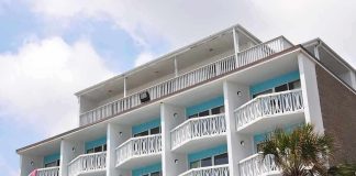 Exterior view of a beachfront hotel with balconies and colorful towels hanging