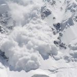 An avalanche occurring on a snowy mountain slope