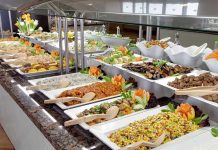 A buffet table displaying a variety of colorful dishes and salads
