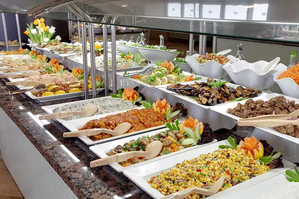 A buffet table displaying a variety of colorful dishes and salads