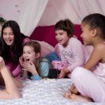 Group of children laughing and enjoying a sleepover in a cozy bedroom