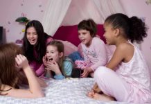 Group of children laughing and enjoying a sleepover in a cozy bedroom