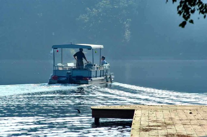 Two people on a boat navigating a misty lake