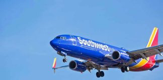 Southwest Airlines plane flying in blue sky.
