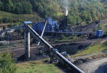 Coal Comeback Shocks Germany’s Climate Plan Industrial coal processing plant with conveyor belts and smokestack.