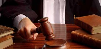 Judges gavel on desk with books.