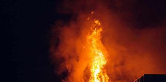 Building engulfed in large flames at night.