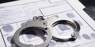 Handcuffs on fingerprint form with fingerprints visible.