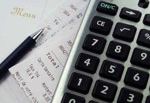 Calculator, pen, and restaurant receipts on a table