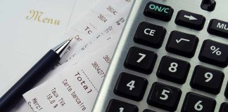 Calculator, pen, and restaurant receipts on a table