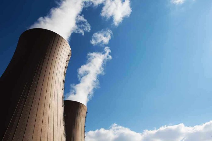Cooling towers of a nuclear power plant emitting steam against a blue sky