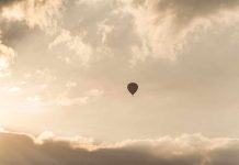 TRAPPED 1,000 Feet Up — Firefighters Attempt Impossible A hot air balloon floating in a cloudy sky during sunset