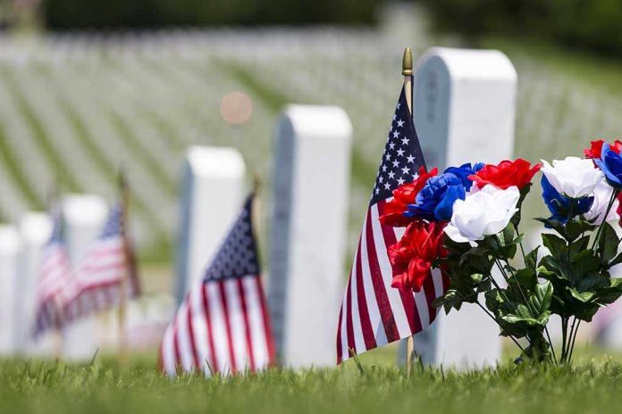 American flags and flowers placed at graves in a cemetery